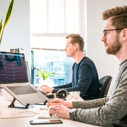 Two people working at computers in an office