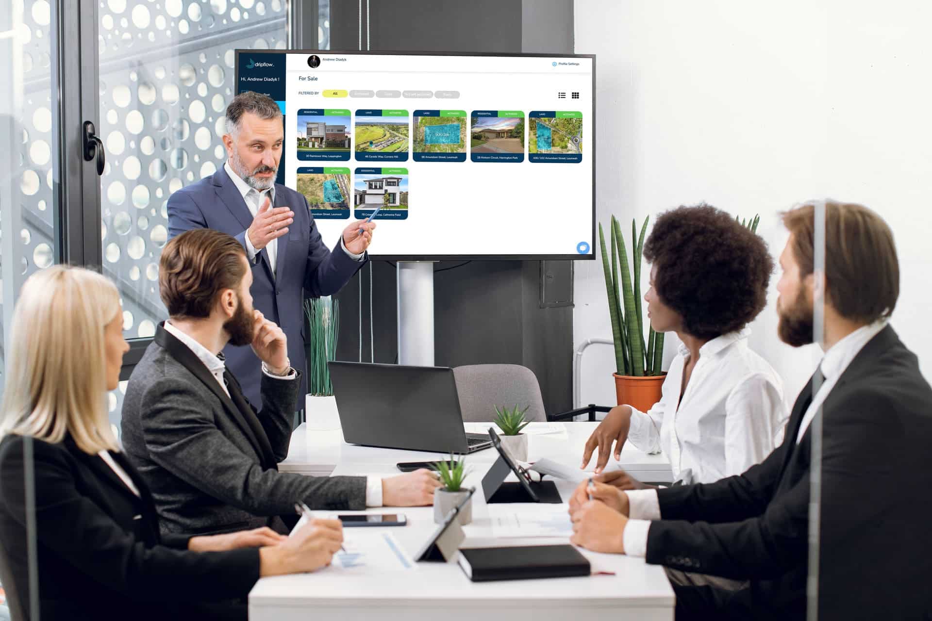 A presenter showing property graphics on a screen in a meeting